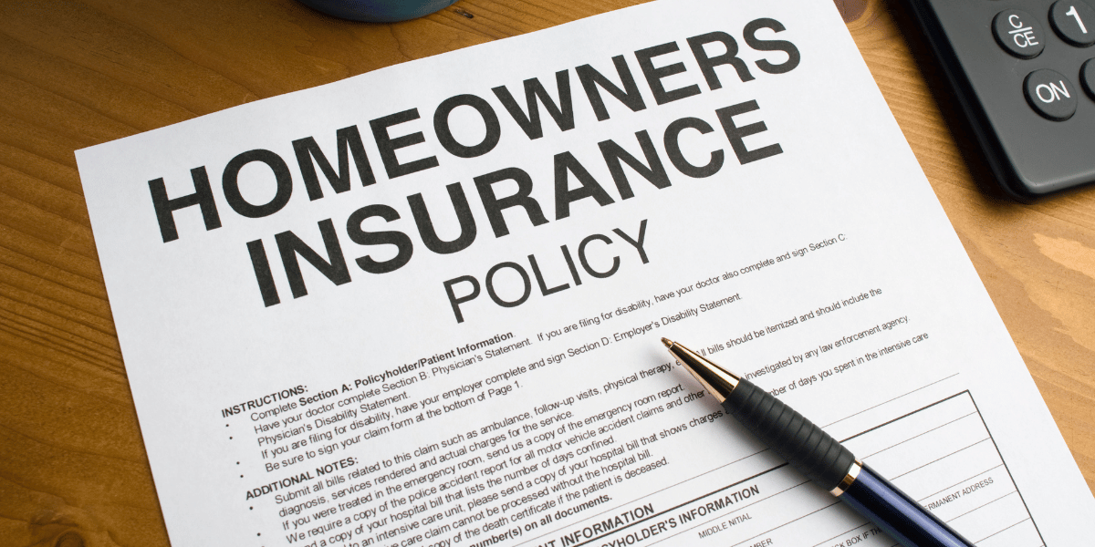 Homeowners insurance policy sitting on desk with pen on top of it